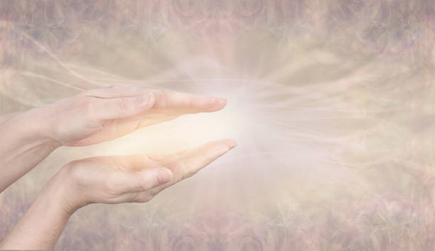 Tuning in to Divine Intelligence healing energy Female parallel hands with beautiful golden glowing energy against a pale wispy flowing golden light background with copy space ether stock pictures, royalty-free photos & images