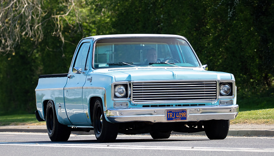 Bicester, Oxon., UK - April 24th 2022. 1976 Chevrolet C10 pick up truck driving on an English country road