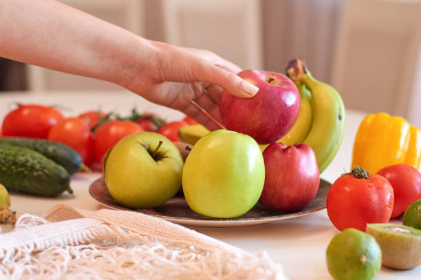 istock Woman hands holding red apple above plate 1478696781