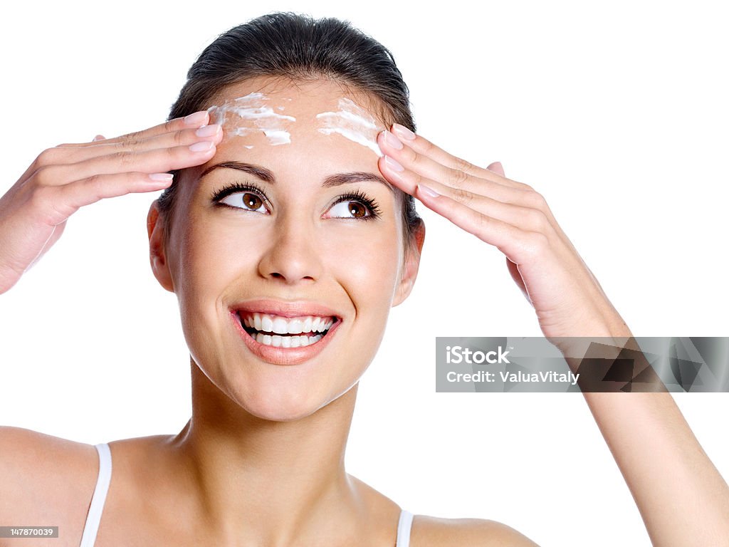 Woman with cream on the forehead looking up Beautiful happy smiling woman with cream on the forehead of her face looking up - isolated 20-29 Years Stock Photo