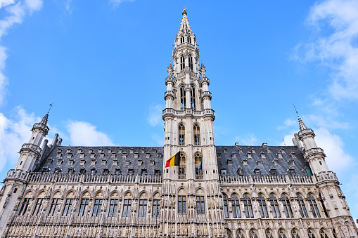 Town hall in the Grand Place from low view. Clear sky with a few clouds on background
