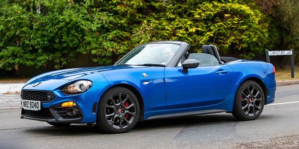 Whittlebury,Northants,UK - August 25th 2022. 2018 1368 cc convertible blue Abarth 124 Spider  travelling on an English country road
