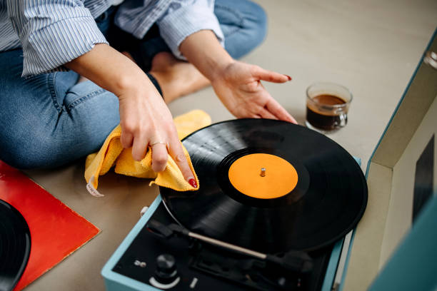 Woman dusts off a record player