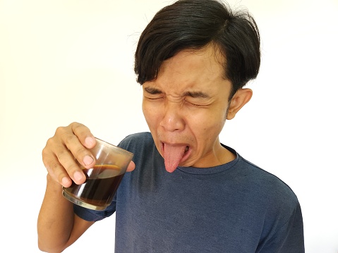 Asian man drink a shot of bitter espresso coffee