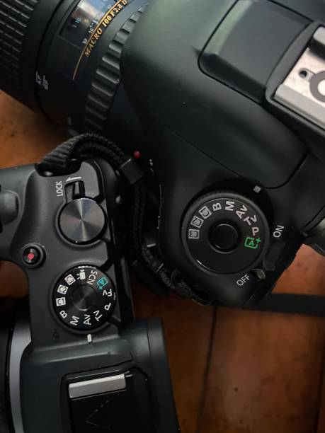 istock Vertical closeup shot of two professional DSLR digital cameras on a table 1478720507