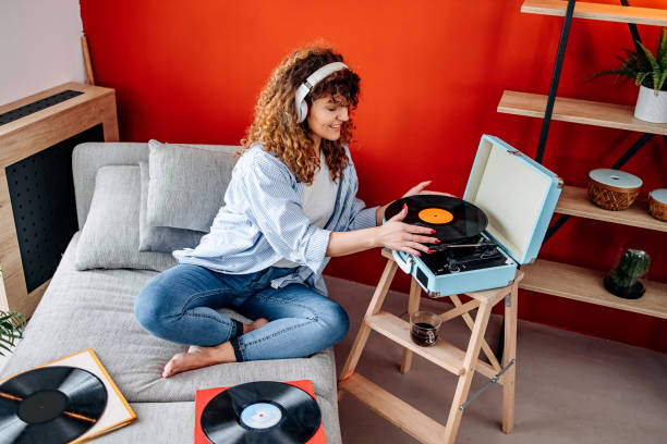 istock Woman using headphone to listen to vinyl record 1478722347