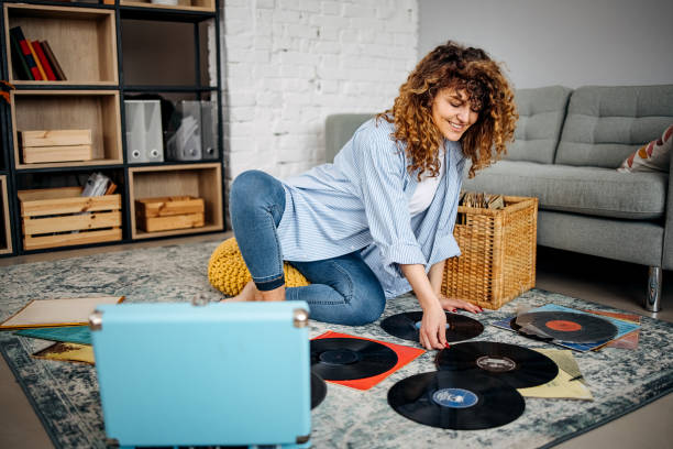 giovane donna sorridente che tiene il vecchio disco di musica in vinile a casa - music women disco joy foto e immagini stock