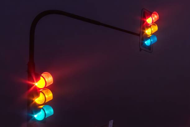 istock Traffic lights shining red, yellow and blue lights at the same time under a dark sky at night 1478724703