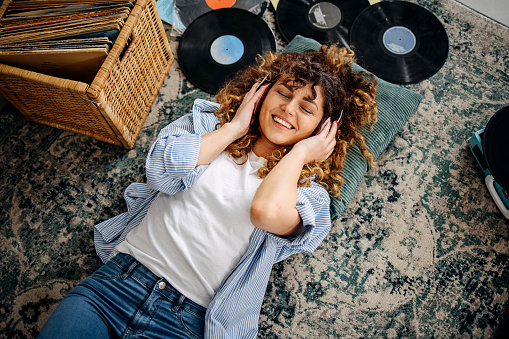 Young beautiful woman is listening old time records at home