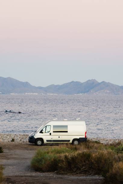 istock White van parked on the beach with a tranquil sea in the background 1478725299