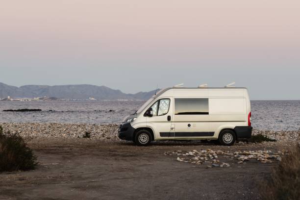 istock White van parked on the beach with a tranquil sea in the background 1478725305