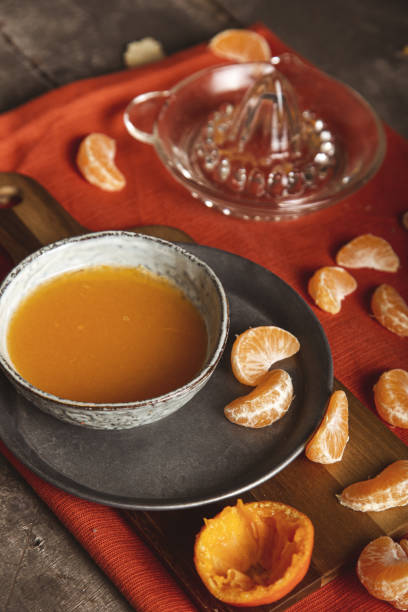 istock Sliced tangerine with juice on a cutting board, table top view. 1478728274