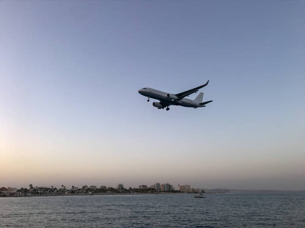 istock Plane landing at sunset over water. 1478728476