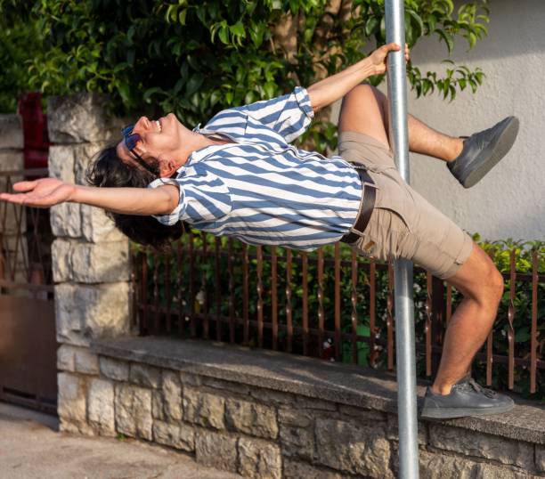 Young happy male posing as a dancer on a pole outdoors