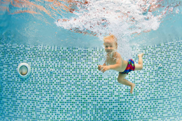 istock Happy child dive underwater with fun in swimming pool 1478730919