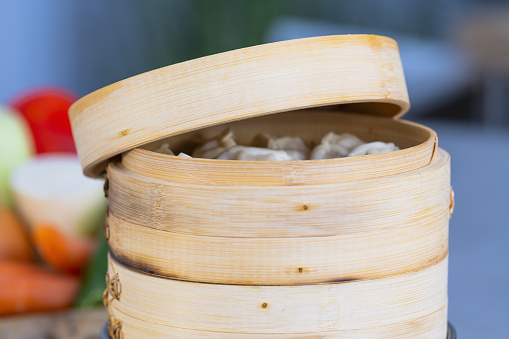 A closeup shot of a bamboo steamer with freshly made dumplings