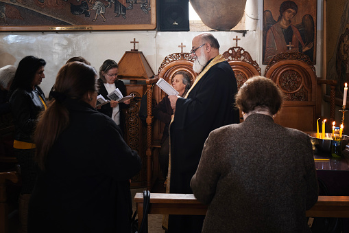 local christian people who attended religious sacrament in St. George's Church which is an early Byzantine church in Madaba, Jordan.