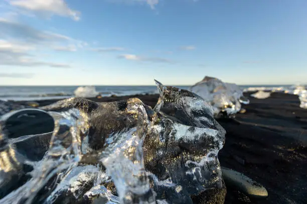 Photo of Selective focus shot of ice rocks scattered on the sandy surface, Iceland