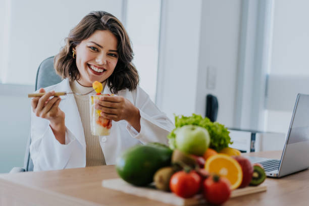 Nutritionist eating fruit salad looking at camera