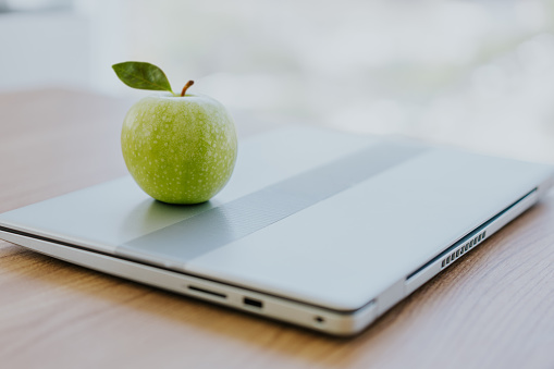 Green apple on top of the laptop