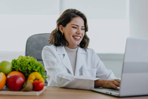 Portrait of a nutritionist doctor working on the laptop Portrait of a nutritionist doctor working on the laptop nutritionist stock pictures, royalty-free photos & images