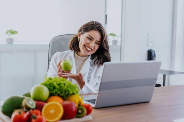 istock Nutritionist assisting patient online holding apple 1478737943