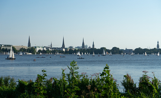 Hamburg, Germany – August 14, 2020: A beautiful lake in Hamburg with sunshine in summer. In the background the skyline.