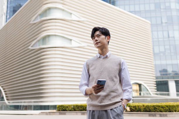 istock Asian white-collar workers are outdoors with a mobile phone in their hand 1478738568