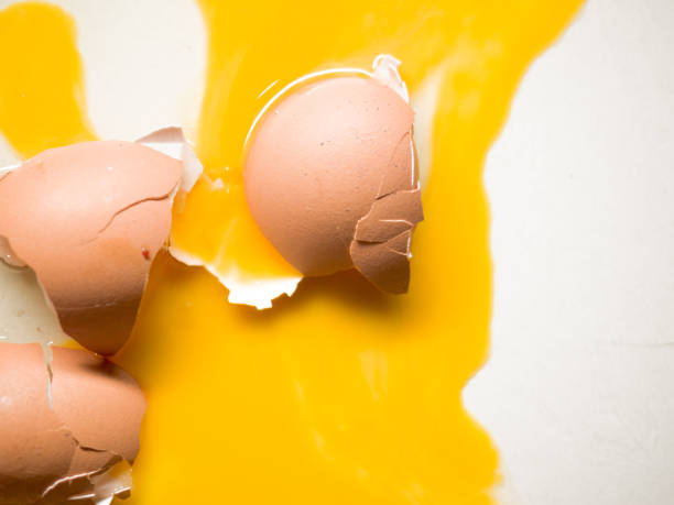istock Closeup shot of broken eggs on a white background 1478738773