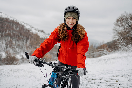 Woman riding a bicycle on a snowy forest road