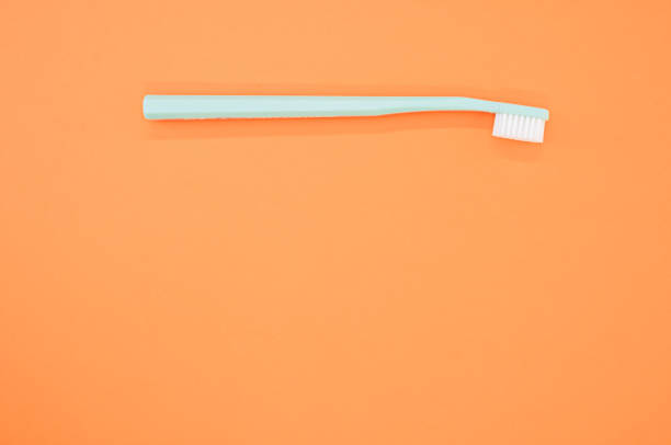 istock New green toothbrush on an orange background 1478739186