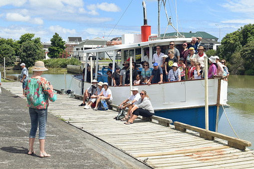 Auckland, New Zealand – January 17, 2021: Group of tourists on board of Manukau Charters Ratahi motor boat returned from cruise at Waiuku River