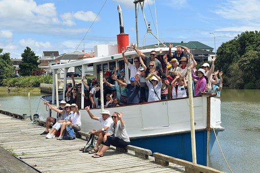 Auckland, New Zealand – January 17, 2021: Group of tourists on board of Manukau Charters Ratahi motor boat returned from cruise at Waiuku River