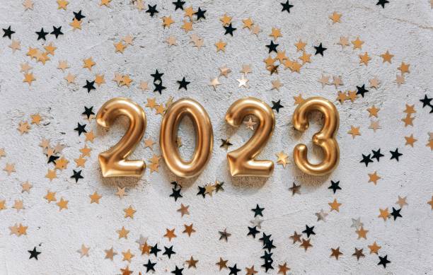 istock Golden numbers 2023 on bright concrete background with star shaped confetti 1478740848