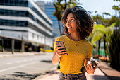 Young woman walking on the street using her cell phone