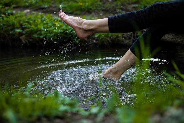 istock Girl tapping water with legs in a forest during the day 1478743965