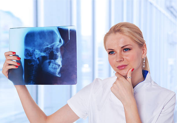 Médico, olhando para a radiografia do seu doente - fotografia de stock