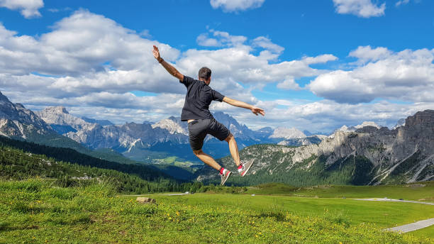 istock Hiker jumping up on the grass-covered meadow overlooking the beautiful mountains 1478749818