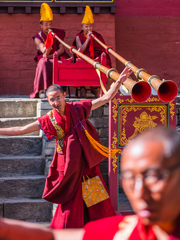 Buddhist monks playing Tibetan dungchen horns and dancing for the Mani Rimdu festival at Tengboche Monastery high in the Himalayan mountains of Nepal.