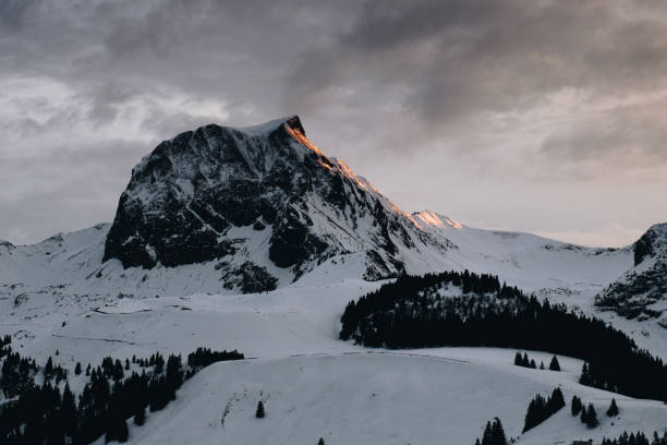 istock Snowy mountain landscape against the bright cloudy sky 1478756440