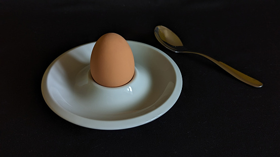 Close up of boiled egg, egg cup and sooon