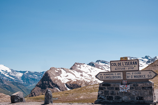 A sunny spring day in the French Alps where a signpost at the highest point along the Col de L'Iseran ( 2770 m) indicates the route to different directions. Popular area for cyclists, motorcyclists and road trips by car.