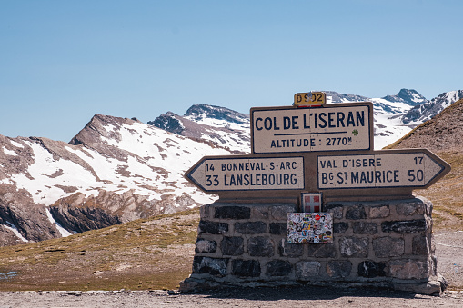 A sunny spring day in the French Alps where a signpost at the highest point along the Col de L'Iseran ( 2770 m altitude) indicates the route to different directions. Popular area for cyclists, motorcyclists and road trips by car.