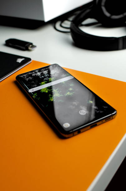 istock Vertical closeup of a smartphone on the orange table 1478759354