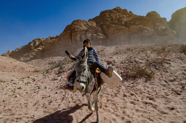 Petra, Jordan – December 12, 2012: Petra, Jordan. December 12th 2012A Jordanian Bedouin boy riding a donkey, Petra, Jordan.