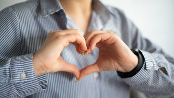 istock Young woman making heart shape with her hand. heart shape on chest 1478761989
