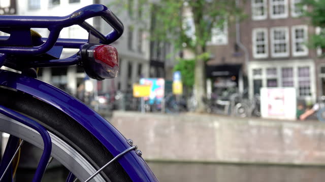 Close-up Bike and Defocused Canal Embankment in Amsterdam