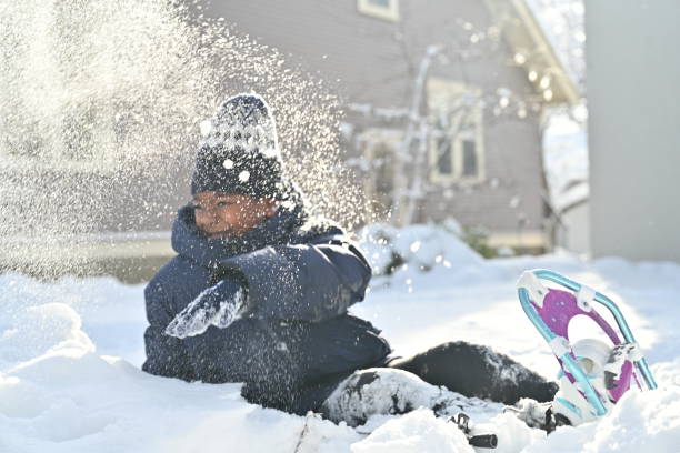 afroamerykański chłopiec bawiący się w śniegu przed domem - snowshoeing snowshoe child winter zdjęcia i obrazy z banku zdjęć