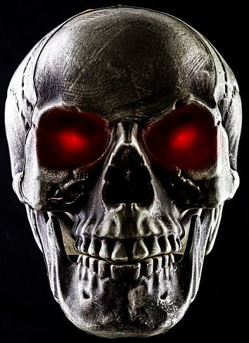 Studio shot of a skeleton skull with Film Noir light setup and glowing red eyes