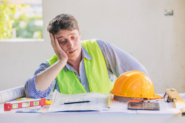 Construction engineers feel boring tired exhausted from overload hard working and building projects problem stock photo